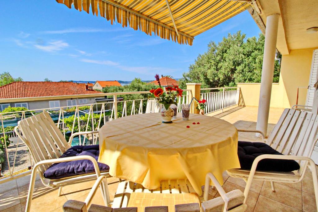 a table with chairs and a vase of flowers on a balcony at Apartment Pehar in Orebić