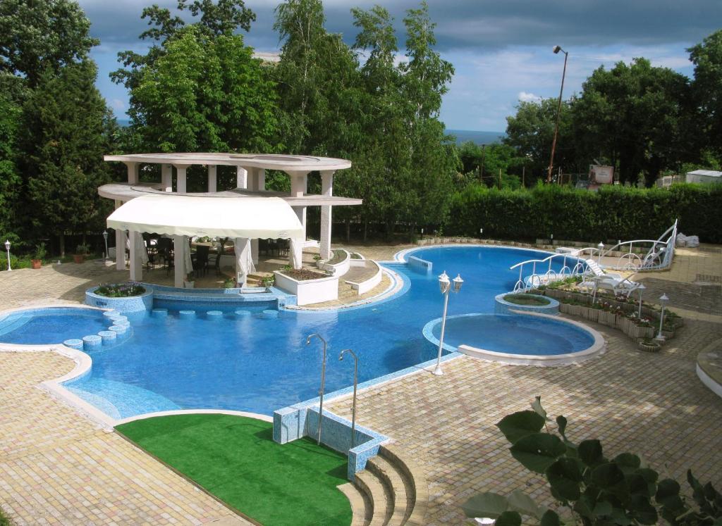 ein großer Swimmingpool mit einem Pavillon in einem Hof in der Unterkunft Park hotel Bellevue in Goldstrand