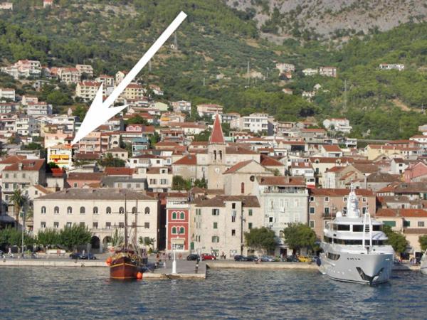 un grand bateau blanc dans l'eau près d'une ville dans l'établissement Apartment Marko, à Makarska