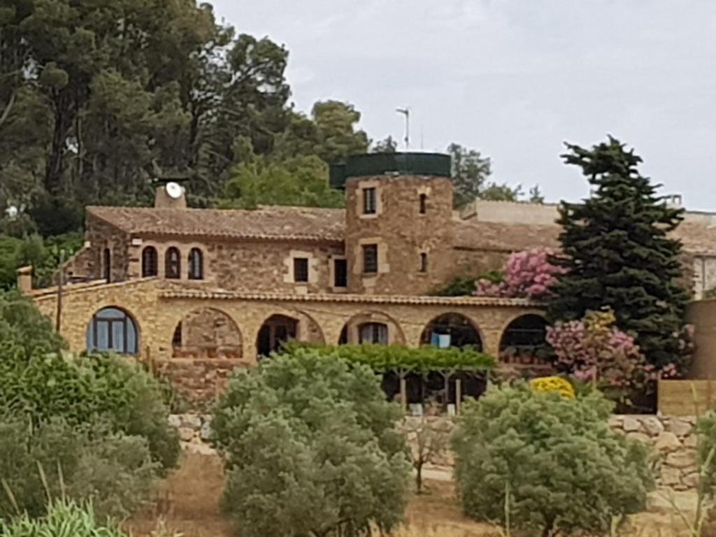 an old stone house with a tower on top of it at Mas Tomas in Vall-Llobrega