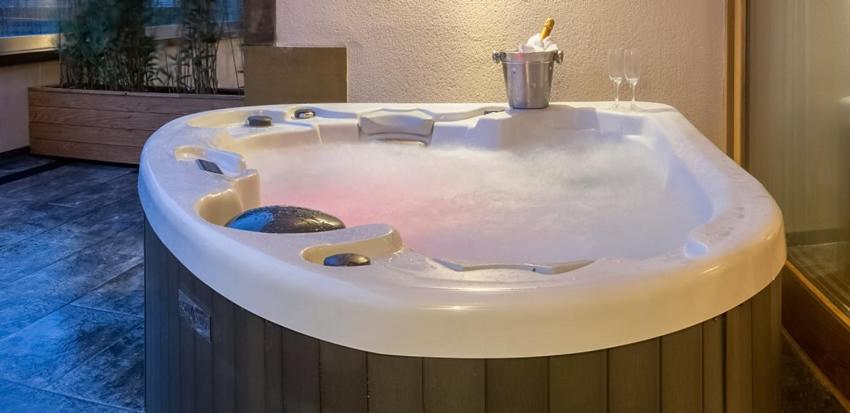 un jacuzzi en una habitación con una vela en Applegarth Villa Hotel & Restaurant (Adult Only), en Windermere