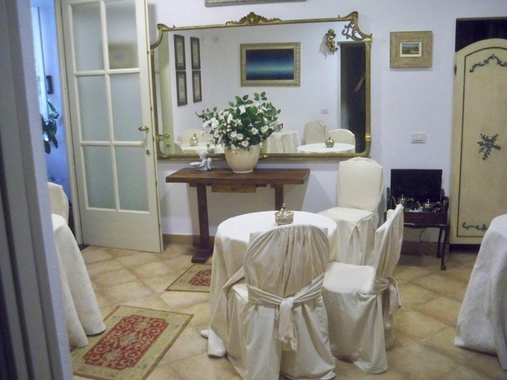 Habitación con mesa, sillas y espejo. en La Dolce Vita en Levanto