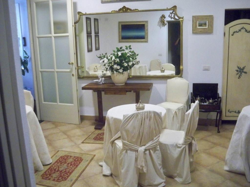 a room with a table and chairs and a mirror at La Dolce Vita in Levanto