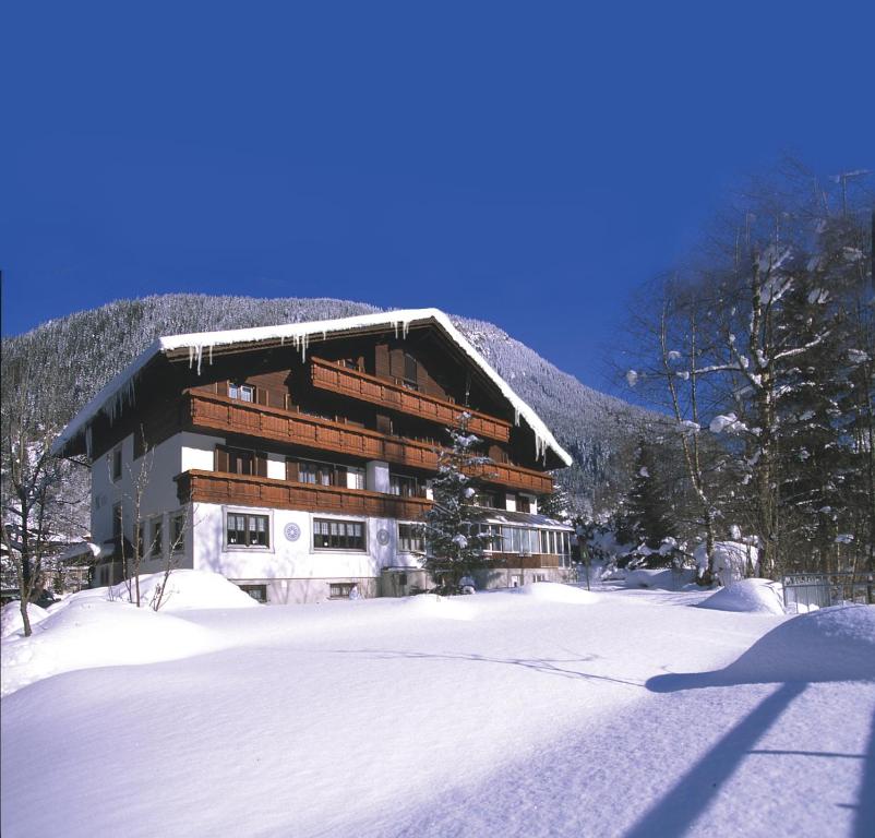 a building with snow on the ground in front of it at Hotel Monika in Gaschurn