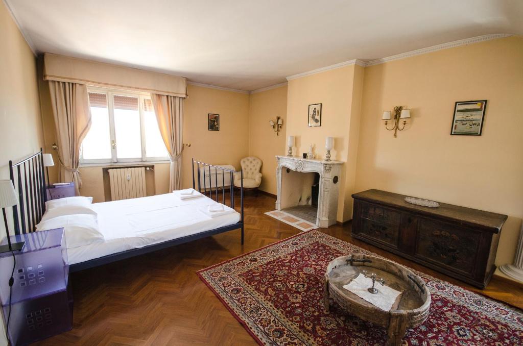 ボローニャにあるS.Orsola Apartmentsのベッドルーム(ベッド1台、テーブル、暖炉付)