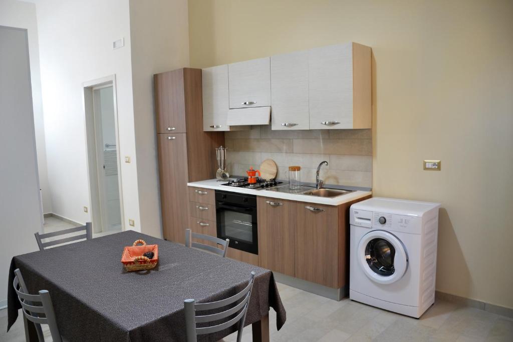 a kitchen with a table and a washing machine at Palazzo Greco Case Vacanze in Porto Cesareo