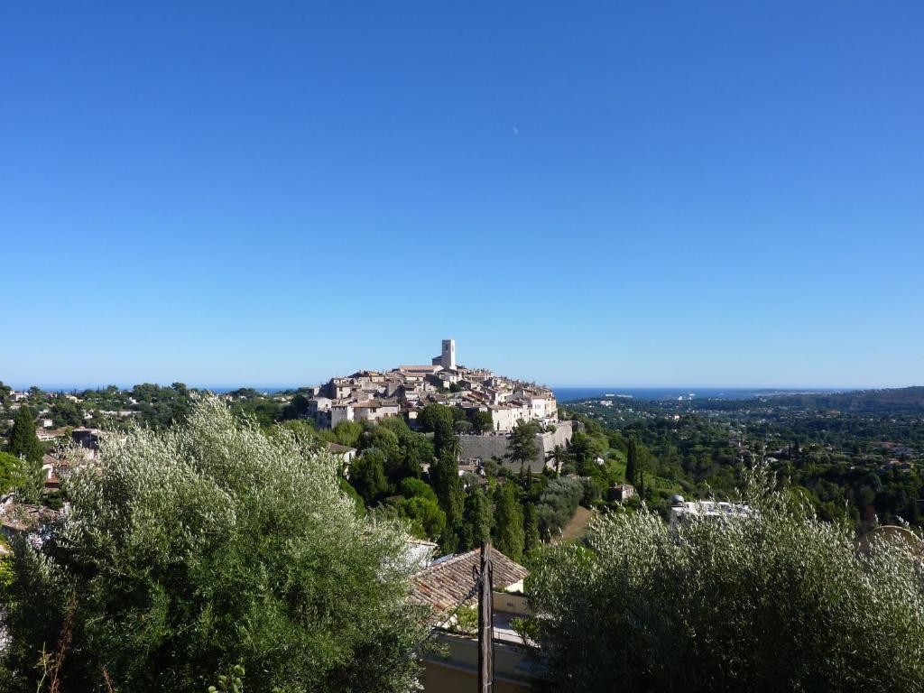 zamek na szczycie wzgórza z drzewami w obiekcie la maison aux bonsais w Saint-Paul-de-Vence