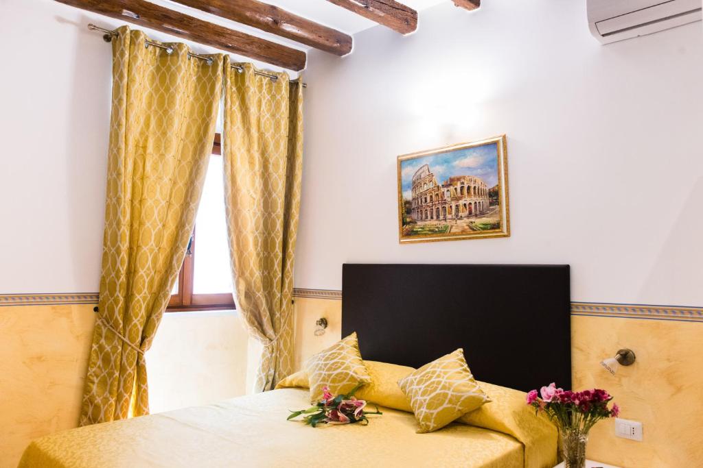 a bedroom with a bed with yellow curtains and a window at Domus Popolo in Rome