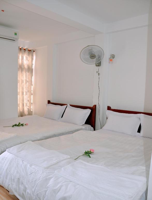 two beds in a room with flowers on them at Ngoc Tung Mini Hotel in Hue