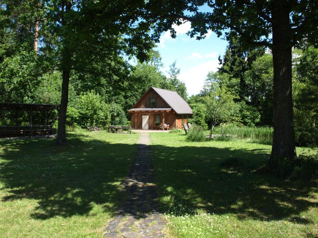 a cabin in the middle of a field with trees at Holiday House Aivari in Inčukalns