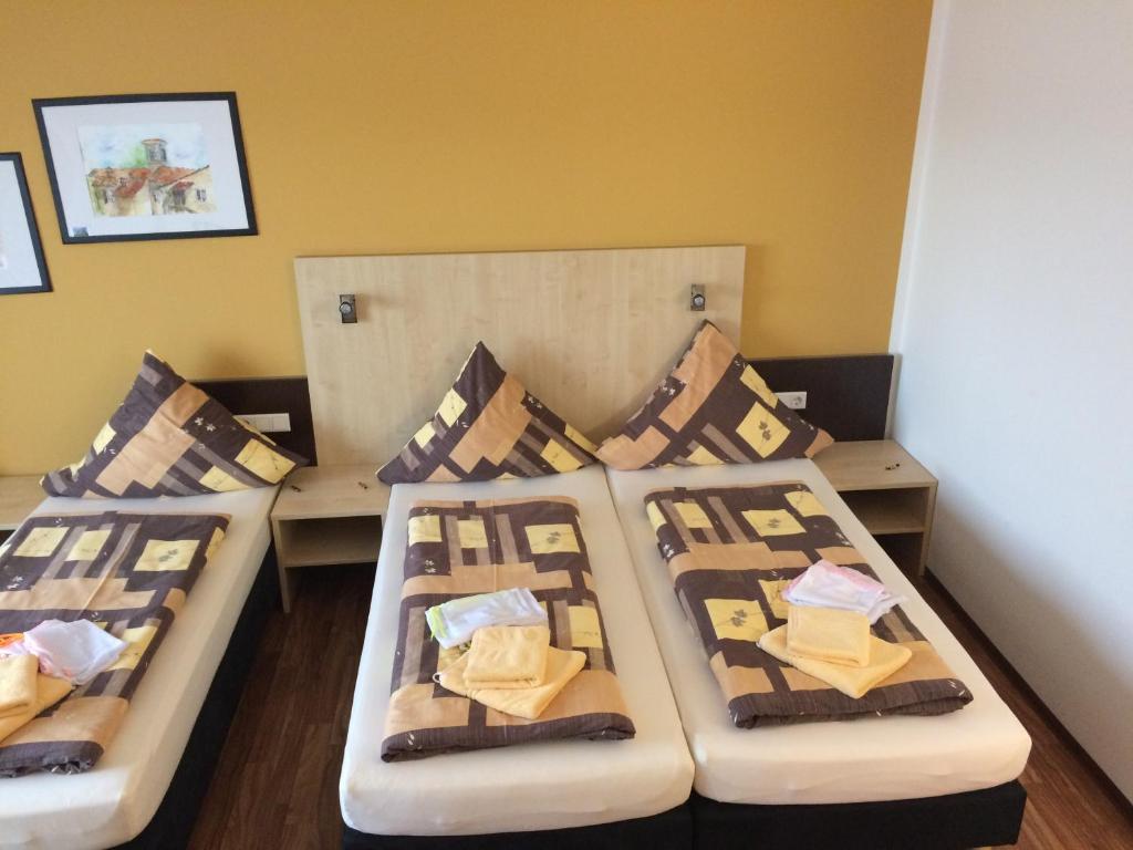 a room with three beds with pillows at Auszeit Cafè & Hotel in Oberwörnitz