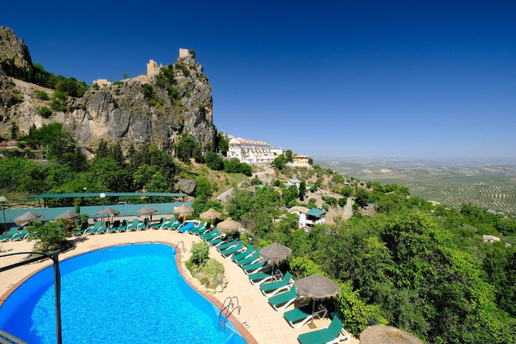 カソルラにあるHotel & Spa Sierra de Cazorla 4*のプールと山のあるリゾートの景色を望めます。
