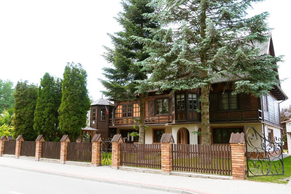 スプラシルにあるApartament w Supraśluの塀と木のある家