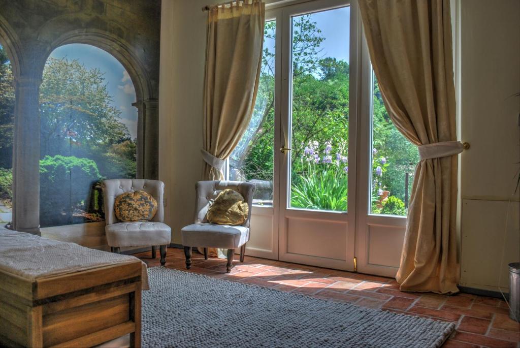 a room with two chairs and a large window at Verdmont in Acqui Terme
