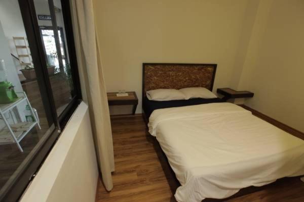 a small bedroom with a bed and a window at Hotel N45 in Kulai