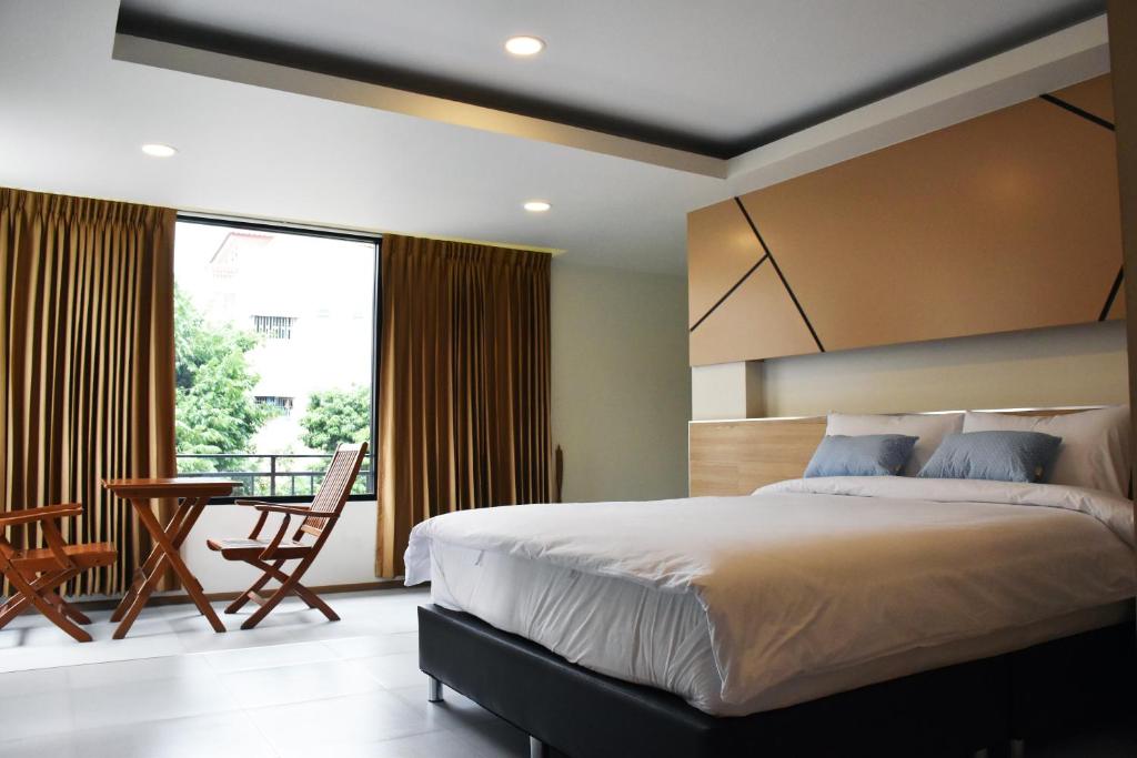 ein Schlafzimmer mit einem großen Bett und einem Balkon in der Unterkunft TUCK Me iN in Chiang Mai