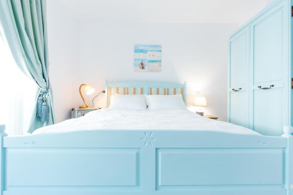 a bedroom with a white bed with a blue canopy at The Shore House in Mamaia Nord