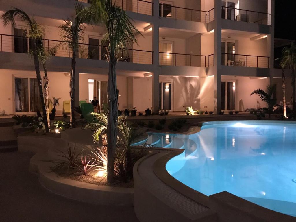a hotel with a large swimming pool at night at Le Cale Camera Privata in Residence in Favignana