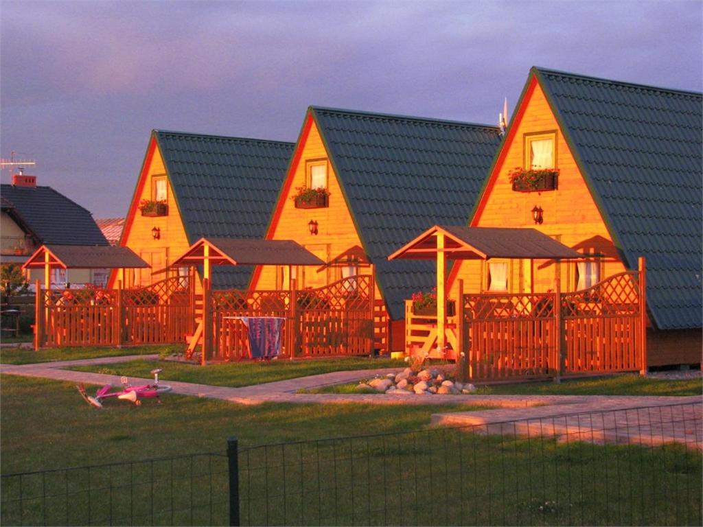 a large house with a fence in front of it at Bajeczne domki in Ustka