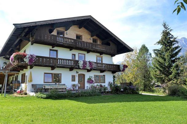 a large house with flowers on the front of it at Lanzenbauernhof in Going am Wilden Kaiser