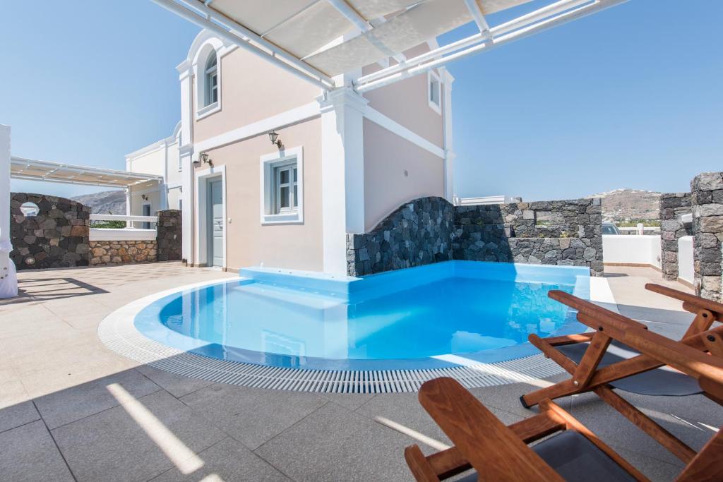 a villa with a swimming pool and a patio at Secret Earth Villas - Santorini in Kamari