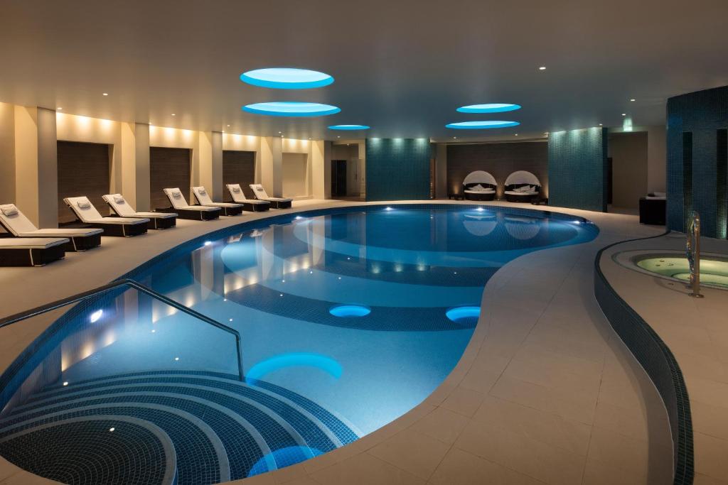 una gran piscina en el vestíbulo del hotel con sillas en Leonardo Hotel and Conference Venue Hinckley Island, en Hinckley