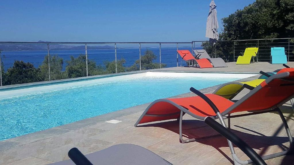 - une piscine avec des chaises à côté de la piscine dans l'établissement Residence Arinella, à Farinole