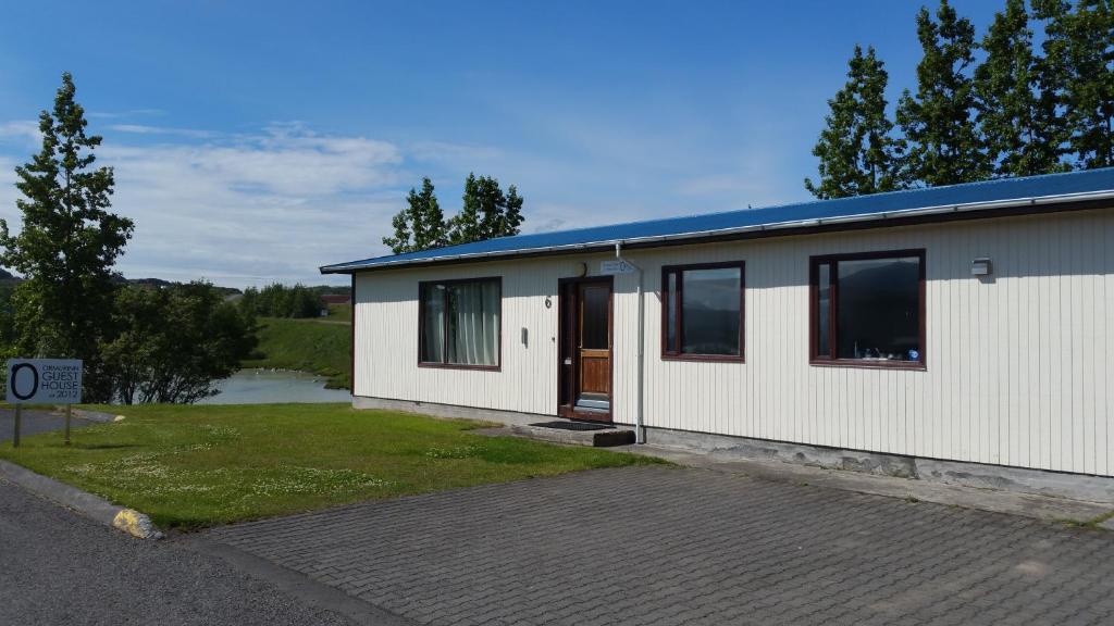 a small white building with a lot of windows at Ormurinn Guesthouse in Egilsstadir