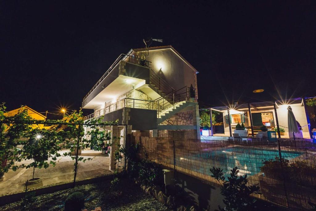 ein Haus mit Swimmingpool bei Nacht in der Unterkunft Holiday Home Gabi in Rogoznica
