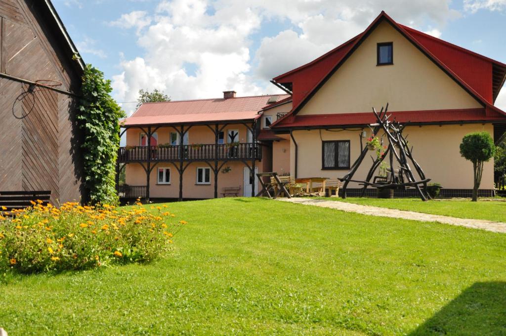 烏斯奇基的住宿－Nad Krolówką，一座有红色屋顶和草地庭院的房子