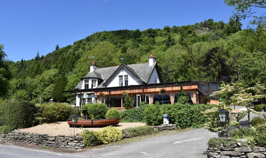 a large house with a mountain in the background at Ailean Chraggan in Aberfeldy