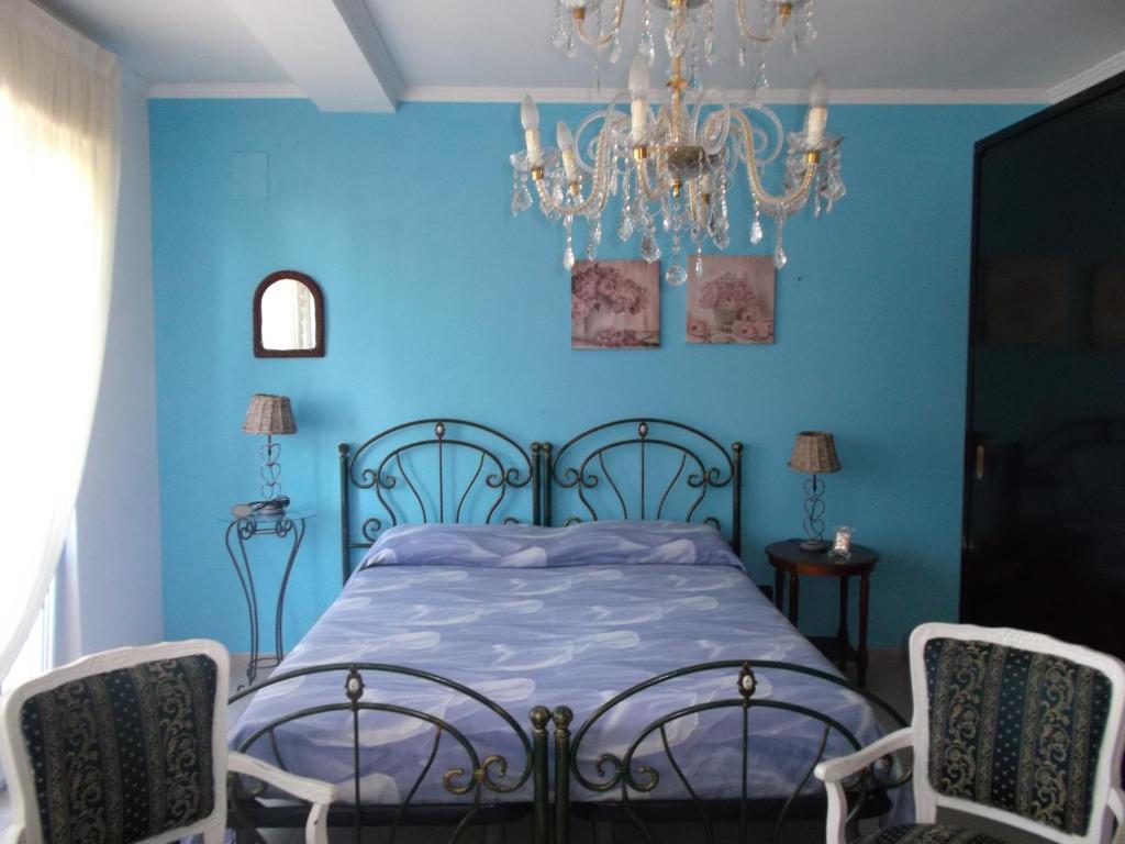 Scalo dei Saraceni ManfredoniaにあるVilla Lucyの青いベッドルーム(ベッド1台、シャンデリア付)