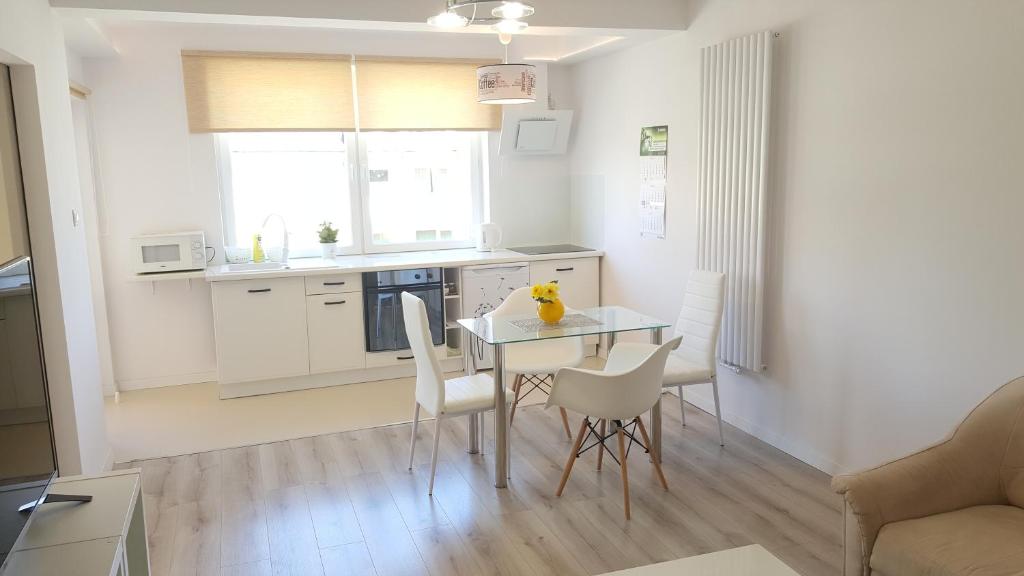 a kitchen and dining room with a table and chairs at Apartament Muszelka in Ustka