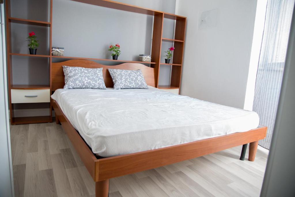 Un dormitorio con una cama grande con cabecero de madera. en Casa Anna, en Quartu SantʼElena