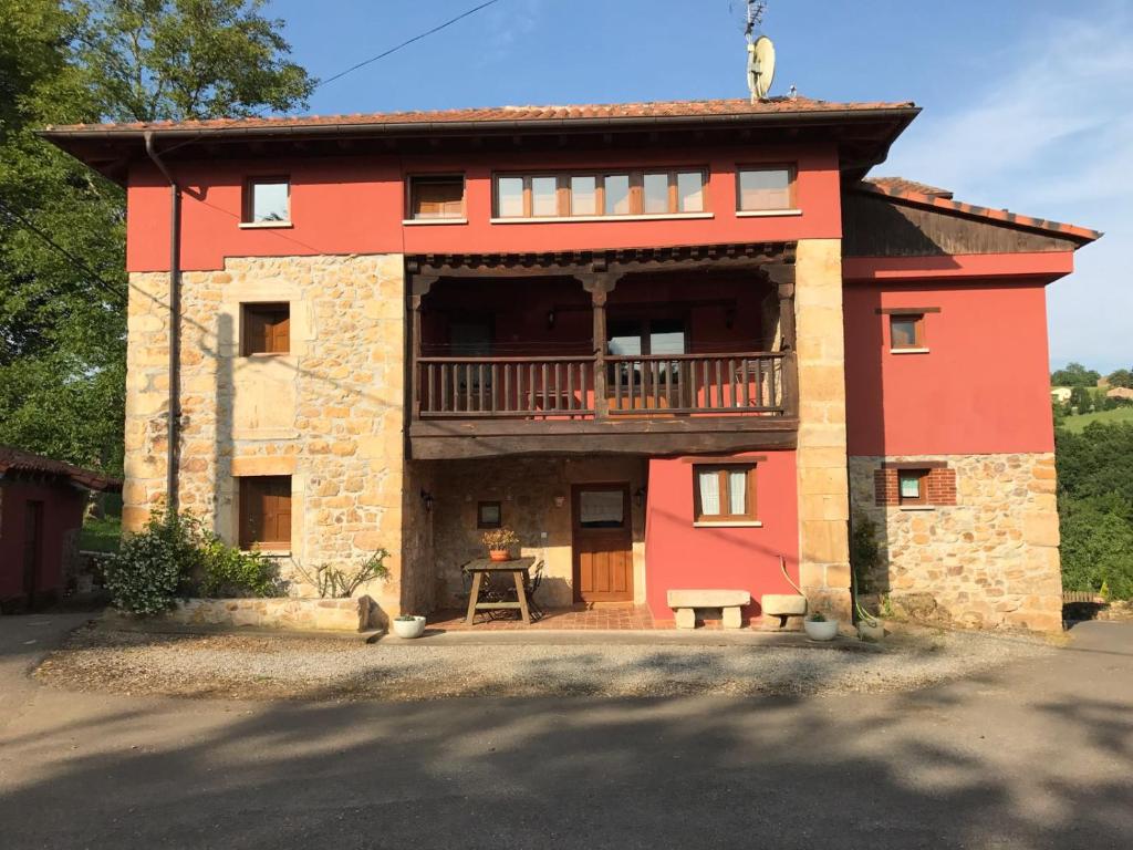 una casa roja con balcón en la parte superior. en Casa Liron en Corao