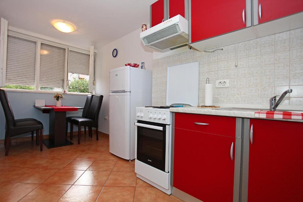 a kitchen with red cabinets and a white refrigerator at Apartment Marko 1 in Split