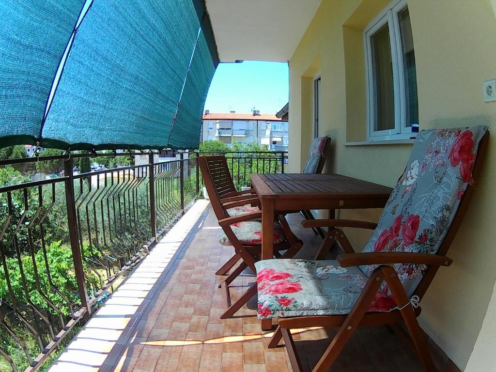 a balcony with a table and chairs and an umbrella at Lea Apartment in Umag