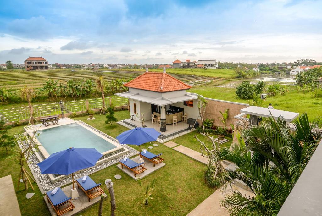 una vista aérea de una casa con piscina y sombrillas en Pondok Canggu Homestay en Canggu