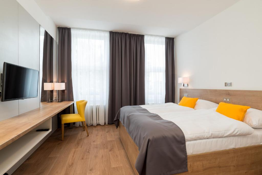 ボスコヴィツェにあるHotel Slaviaのベッド、デスク、テレビが備わるホテルルームです。