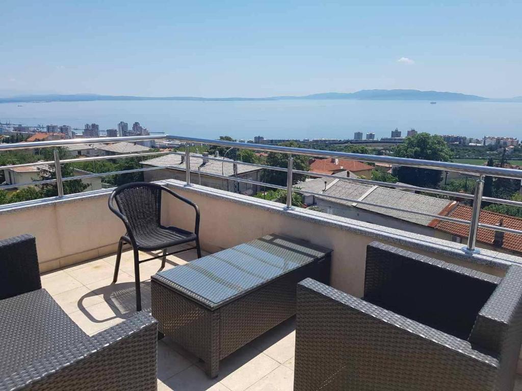 un balcón con una silla y un banco en el techo en Peachy House en Rijeka