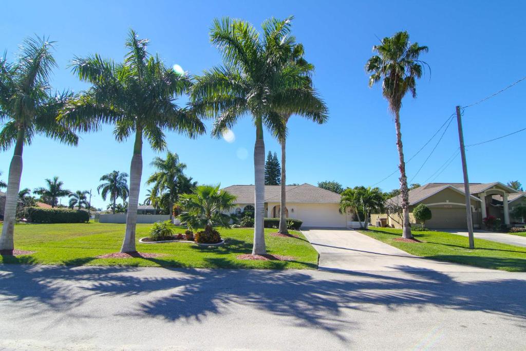 a driveway with palm trees in front of a house at Villa Joella in Cape Coral