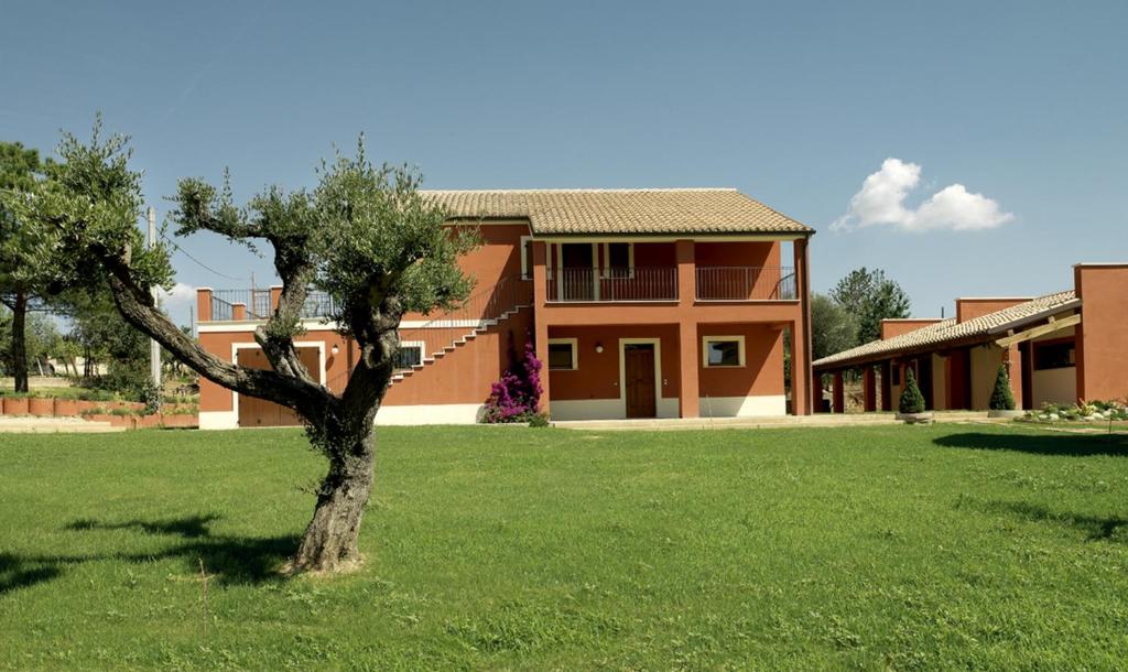 a house with a tree in the middle of a yard at Contado San Lorenzo B&B and Wine in Castilenti