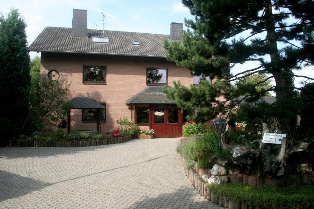 una casa con una puerta roja en una entrada de ladrillo en Ferienwohnung-Geschwind en Schleiden
