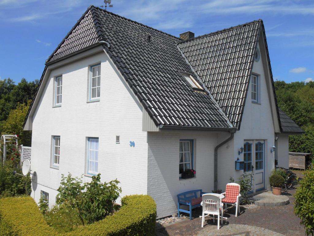 a white house with a black roof at Ferienwohnung-Moltrecht-2 in Laboe
