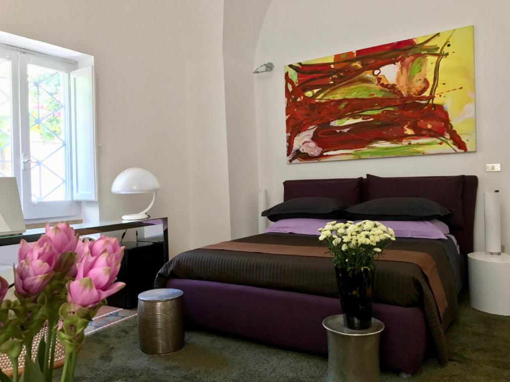 a bedroom with a bed and a painting on the wall at ART TO DESIGN B&B in Lecce