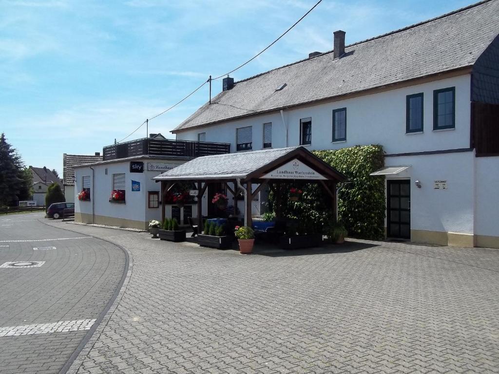 un edificio con una tienda de campaña delante de él en Landhaus Wartenstein, en Oberhausen