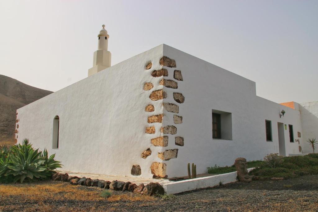 una chiesa bianca con un faro sopra di Casa Rural los Ajaches a Yaiza