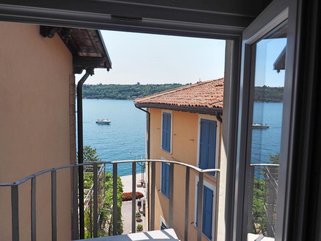 een uitzicht op het water vanuit een raam van een gebouw bij Appartamenti al Golfo in Salò