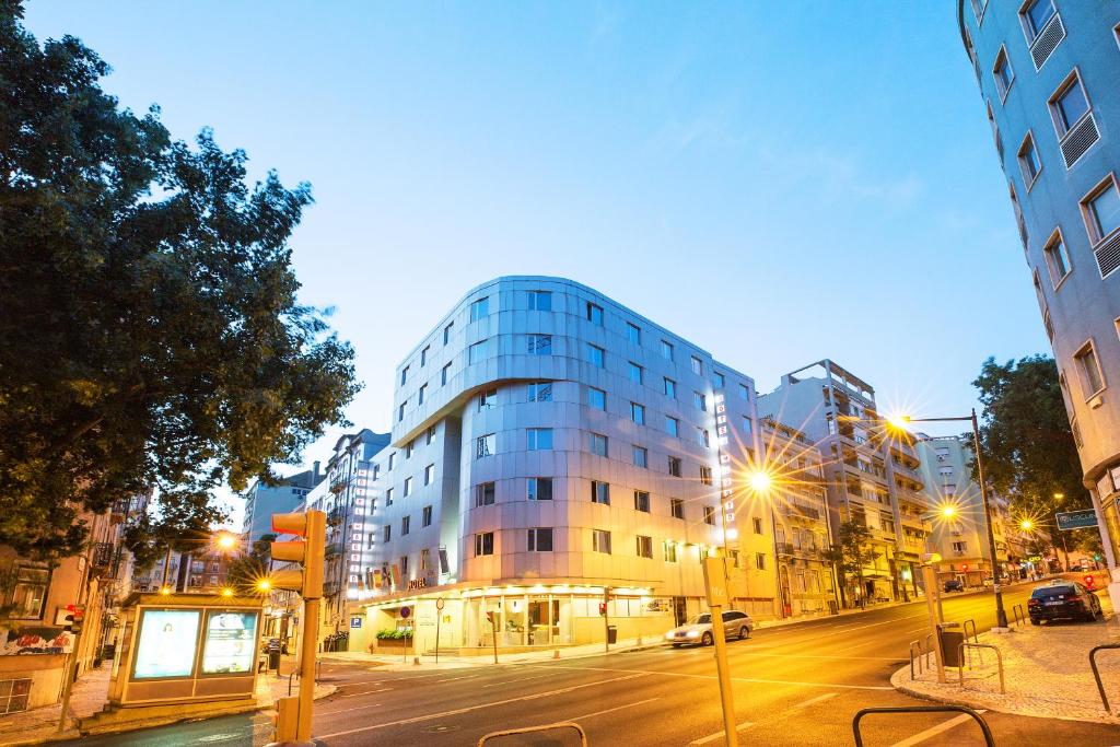 un edificio alto en una calle de la ciudad por la noche en Hotel 3K Madrid, en Lisboa
