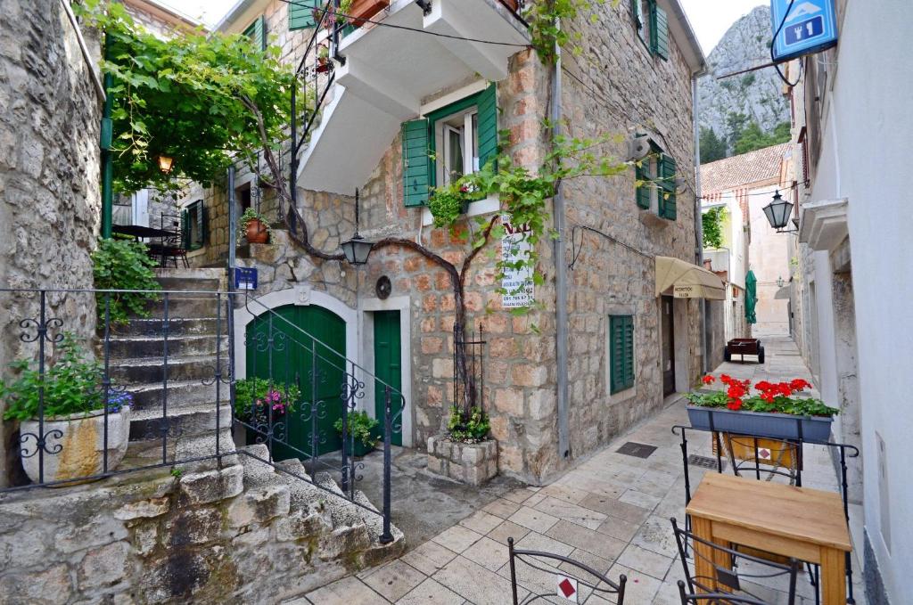 een steegje in een oud stenen gebouw met groene deuren bij Apartments Lola in Omiš